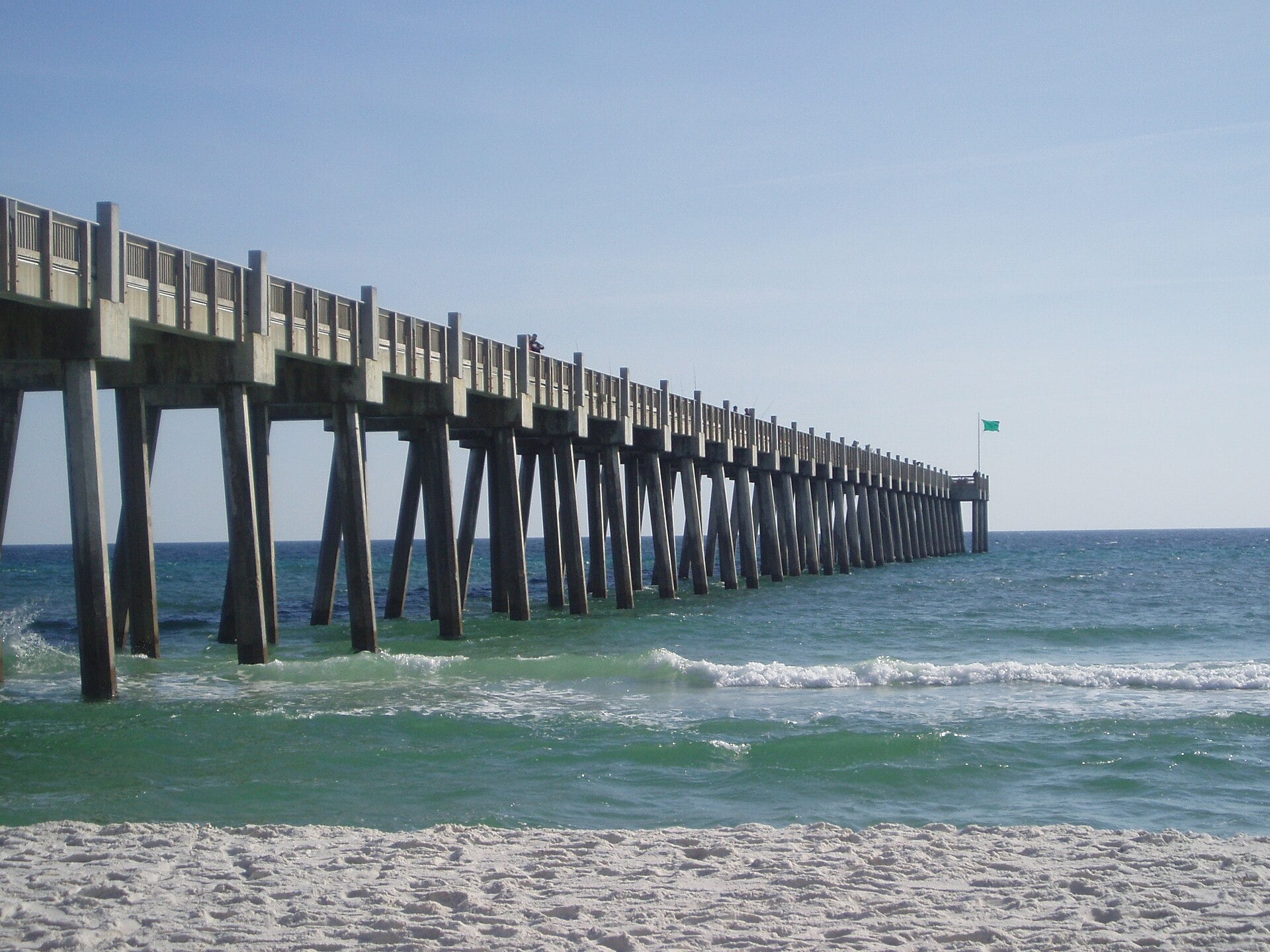El largo muelle de concreto Gulf Pier se extiende sobre el agua verde de Pensacola Beach