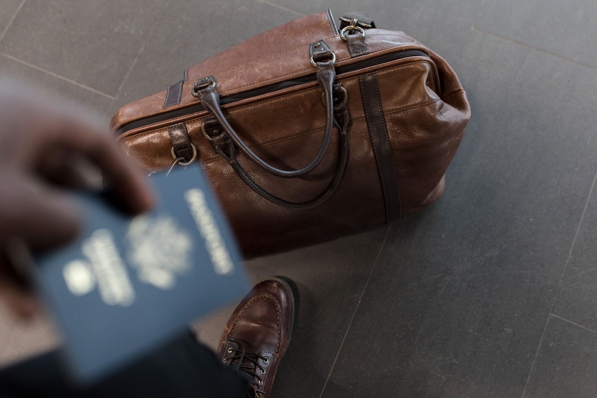 A passport resting on a blue travel suitcase